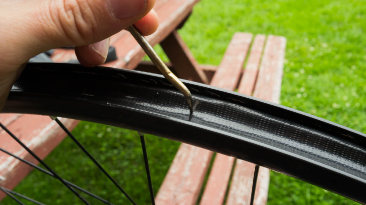 Use a pick to make a hole directly above the valve hole in the rim.