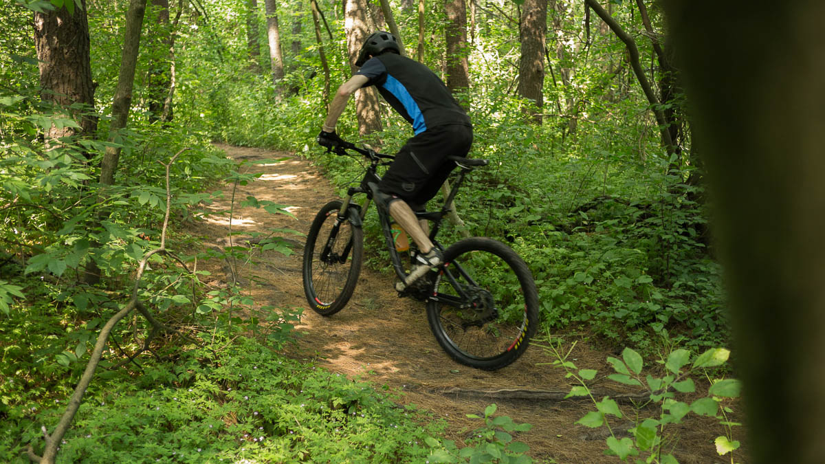 Climbing over some roots on a mountain bike.